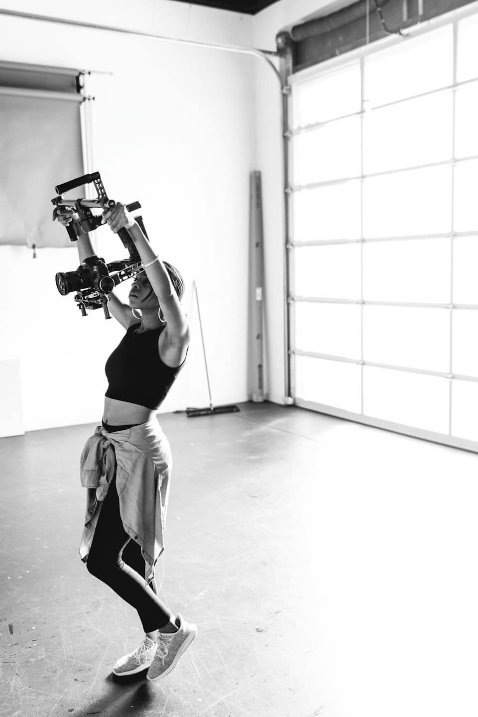 Frau hält professionelles Kamera-Rig hoch im Studio.